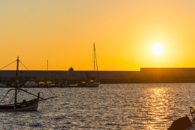 Alghero liman alacakaranlıkta üzerinde parlayan güneş