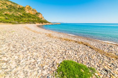 Çakıl taşları ve mavi deniz Baccu e Praidas Beach,