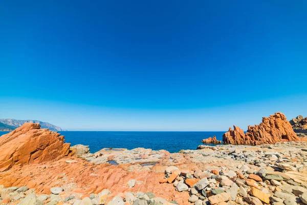 Plage de rochers rouges sous un ciel bleu — Photo