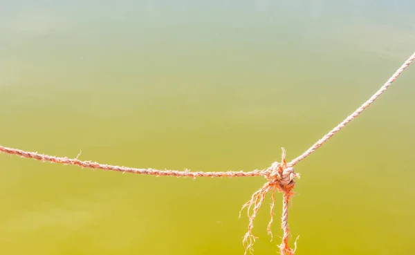 Feche um nó de corda sobre a água — Fotografia de Stock