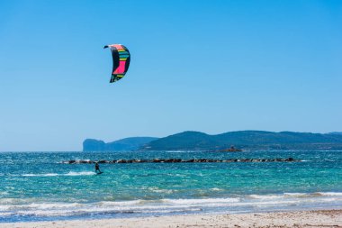 Arka planda Capo Caccia ile uçurtma sörfçü