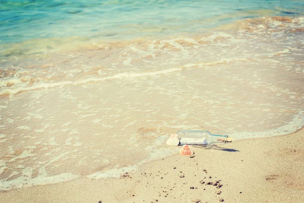 Botella con mensaje en la orilla del mar — Foto de Stock