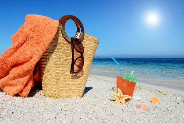 Straw bag, beach towel and cocktail — Stock Photo, Image