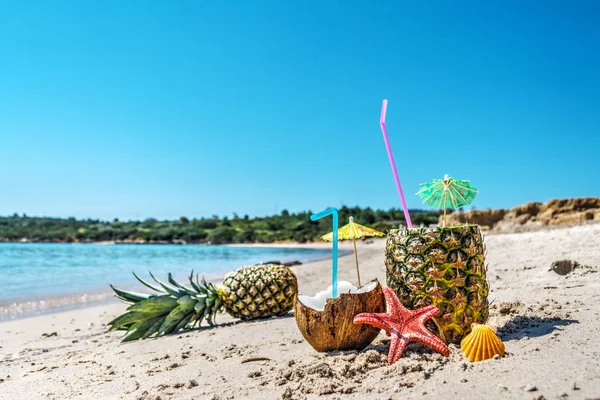 Närbild på ananas och kokosnötter vid stranden — Stockfoto