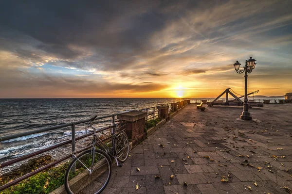 Fiets- en katapult in Alghero kust bij zonsondergang — Stockfoto