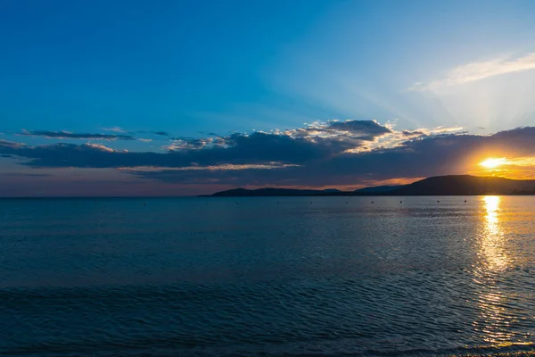 Molnig himmel över havet vid solnedgången — Stockfoto