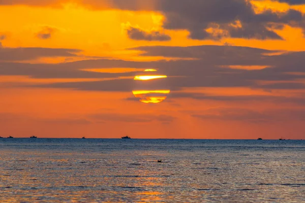 Mörka moln och solen över havet vid solnedgången — Stockfoto