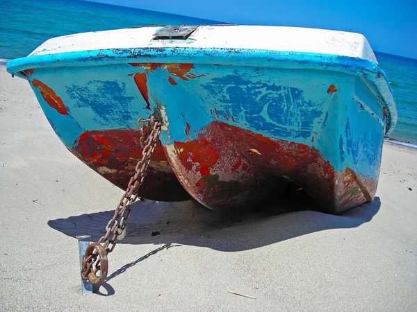 Barco amarrado por uma corrente de metal na areia — Fotografia de Stock