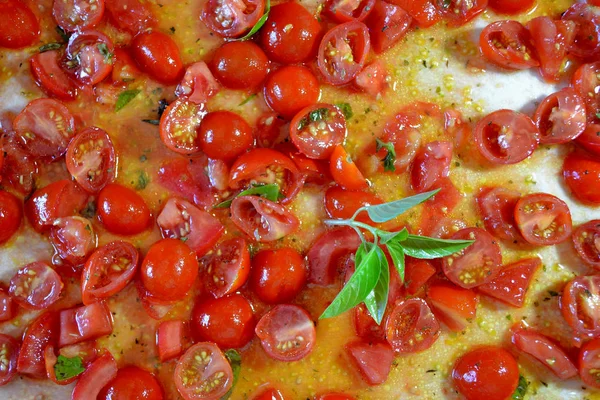 Basil leaves on an uncooked pizza — Stock Photo, Image