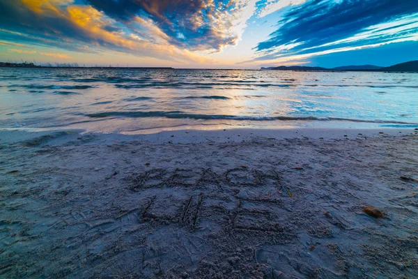 夕暮れ時の砂に書いたビーチ ライフ — ストック写真