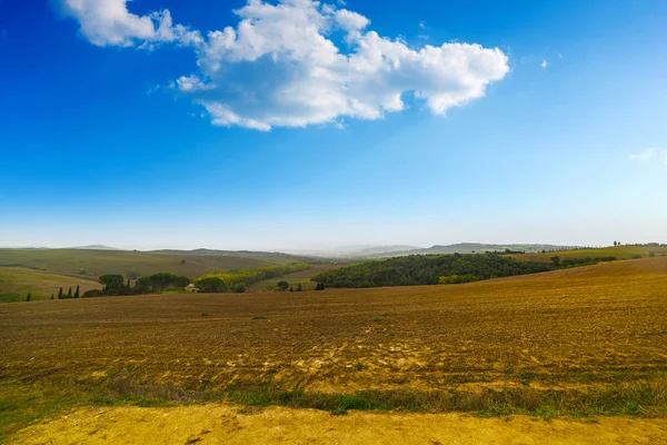 Nuvole su un campo marrone — Foto Stock