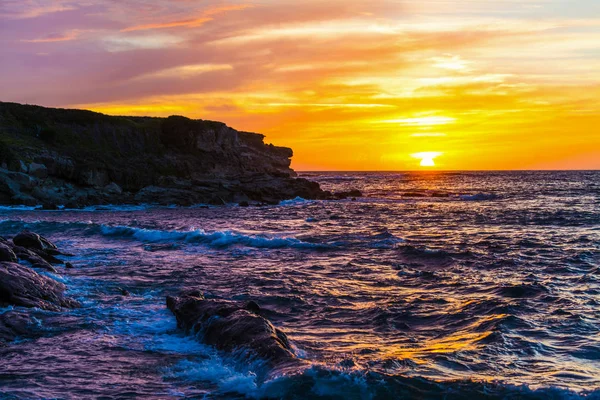 Färgglada himlen över Porto Ferro rocky shore vid solnedgången — Stockfoto