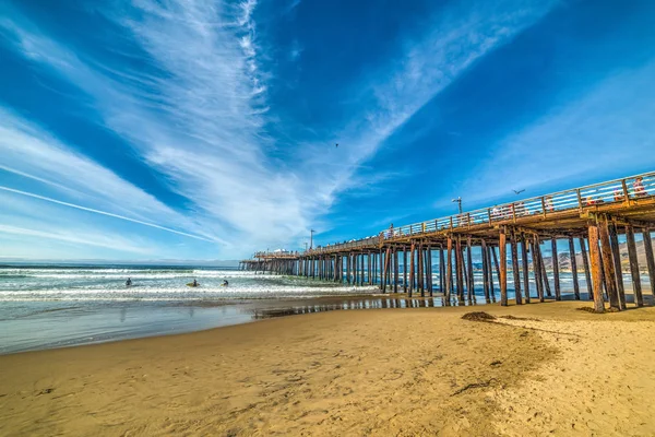 Surfeurs près de la jetée à la plage de Pismo — Photo