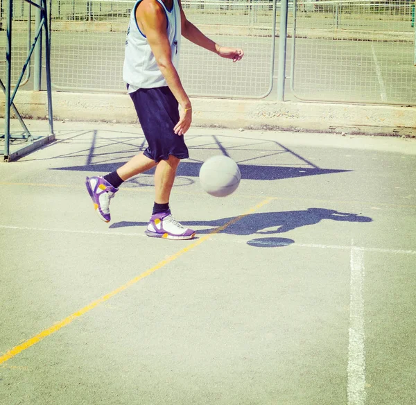 Jugador de baloncesto dribleando en un patio de recreo — Foto de Stock