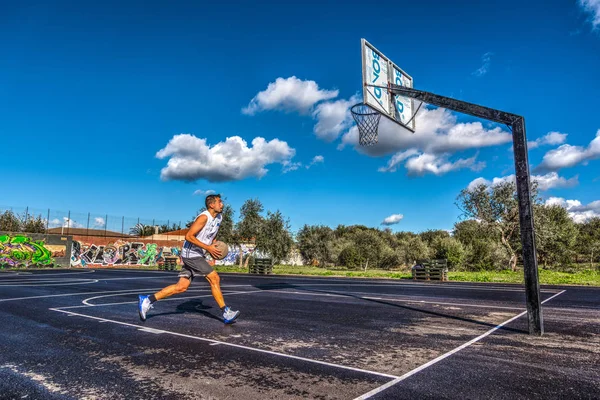 Jogador de basquete carregando o salto para o aro — Fotografia de Stock