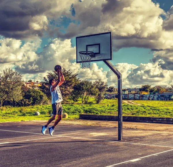 Jogador de basquete esquerda pulando para o aro — Fotografia de Stock