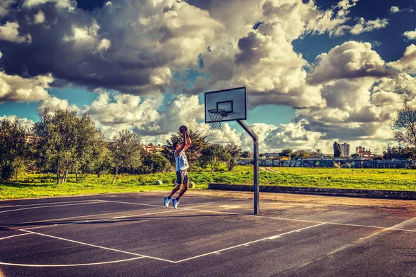 Jogador de basquete esquerda pulando para o aro — Fotografia de Stock