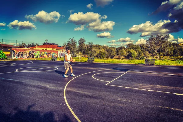 Jogador de basquete esquerda carregando um tiro de três pontos — Fotografia de Stock