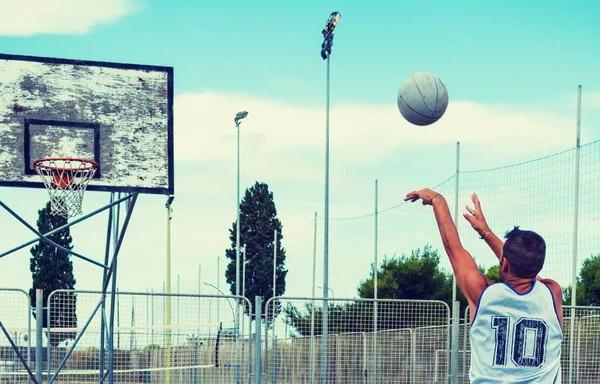 Jogador de basquete de esquerda atirando em um playground — Fotografia de Stock