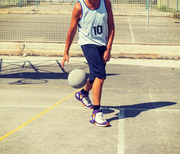 Баскетболист капает между ног — стоковое фото