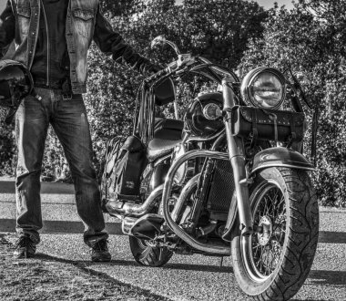 Klasik motosiklet ve motorcu siyah yolun kenarında bir