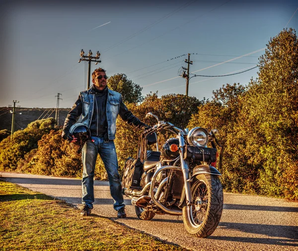 Motociclista em pé por uma motocicleta clássica — Fotografia de Stock