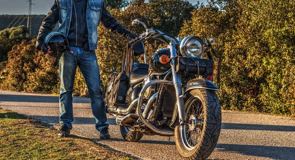 Motocicleta clássica e motociclista na beira da estrada — Fotografia de Stock