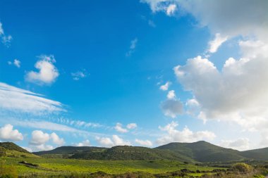 İlkbaharda güzel bir gökyüzünün altında yeşil tepeler