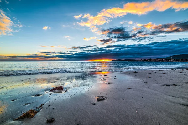 Písečné pobřeží pod barevné nebe při západu slunce — Stock fotografie