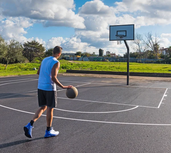Basketballspieler dribbelt auf einem Spielplatz — Stockfoto
