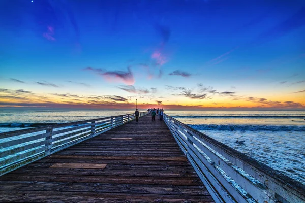 Persone al molo Pacific Beach al tramonto — Foto Stock