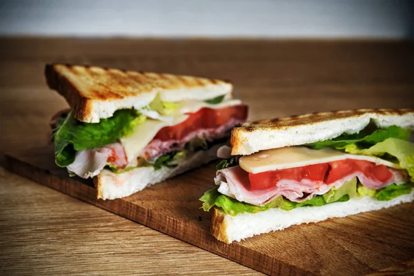Mitades sándwich en una tabla de cortar — Foto de Stock