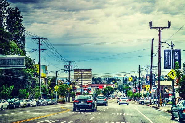 Trafik på Sunset boulevard under en molnig himmel — Stockfoto