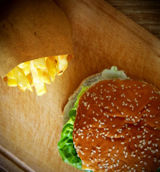 Гамбургер и картошка фри на деревянном столе — стоковое фото