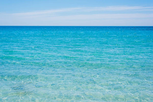 Agua turquesa bajo un cielo despejado en Cerdeña — Foto de Stock