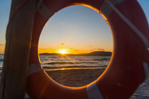 Colorido atardecer en el mar visto a través de una boya salvavidas —  Fotos de Stock