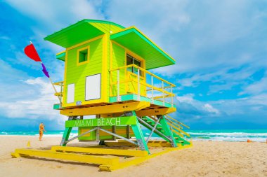 Miami Sahili 'ndeki sarı ve yeşil cankurtaran kulesi.