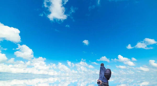 Man med selfie stick under en blå himmel med moln — Stockfoto