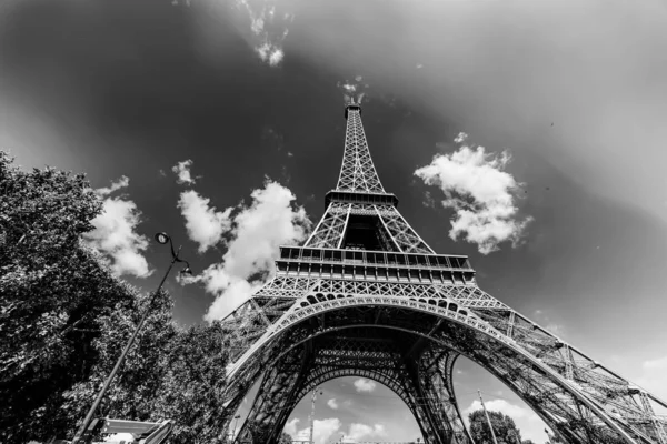 Torre Eiffel mundialmente famosa sob um céu azul com nuvens em preto — Fotografia de Stock