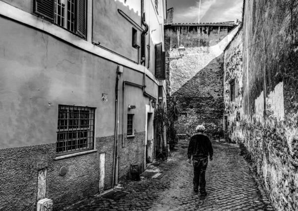 Oude man in een smalle straat in zwart-wit — Stockfoto