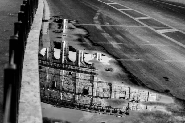 Coliseu mundialmente famoso refletido em uma poça — Fotografia de Stock