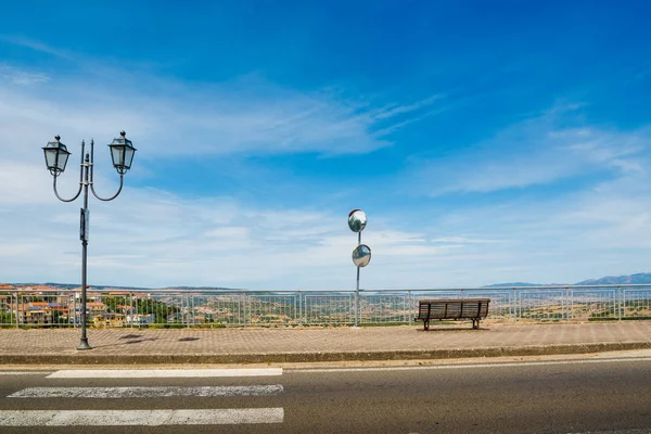 Wooden bench and lamppost on a sidewalk in Sardinia — 스톡 사진