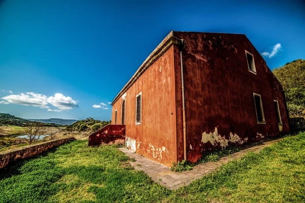 Antigua casa naranja bajo un cielo azul en el campo — Foto de Stock