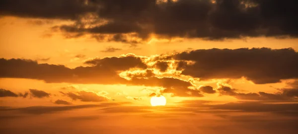 Skiner solen och mörka moln vid solnedgången — Stockfoto