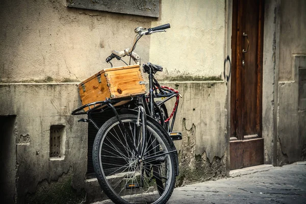 Bicicleta vieja con caja de madera apoyada contra una pared en Florencia — Foto de Stock