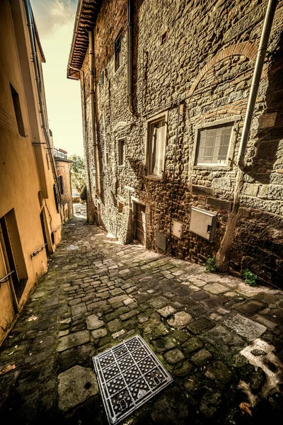 Enge gepflasterte Straße in einer kleinen Stadt in der Toskana — Stockfoto