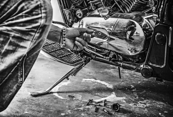 Man repairing a classic motorcycle in black and white — Stock Photo, Image