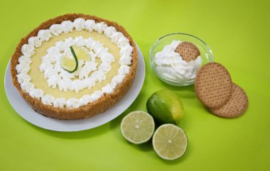 Key Lime Pie with ingredients on a green background clipart