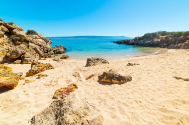 Alghero sahilindeki küçük bir koyda beyaz kum ve kayalar.
