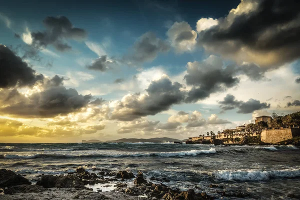 Rivage rocheux sous un ciel spectaculaire au coucher du soleil à Alghero — Photo